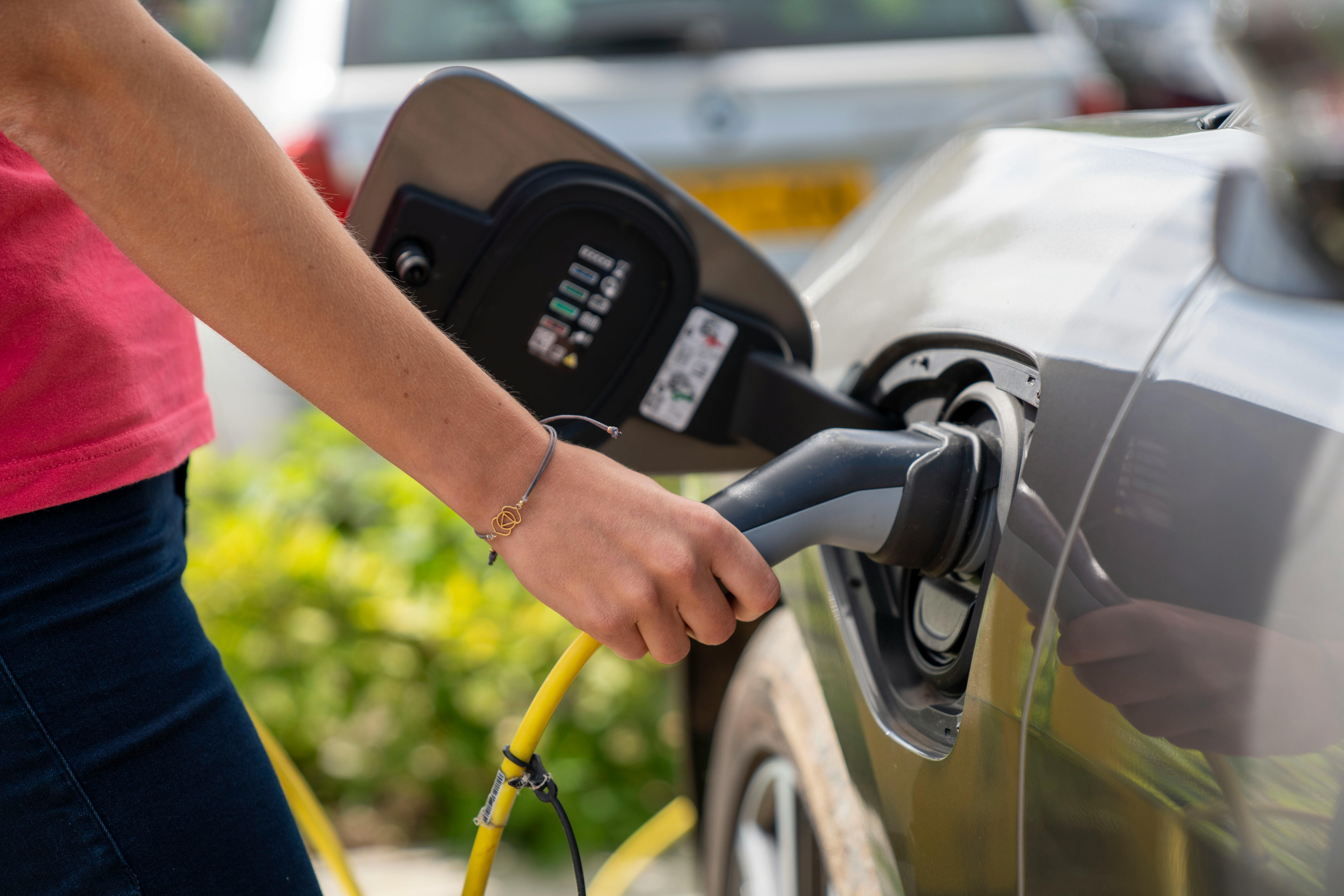 Įkraunamas hibridinis automobilis prijungtas prie elektros įkrovimo laido